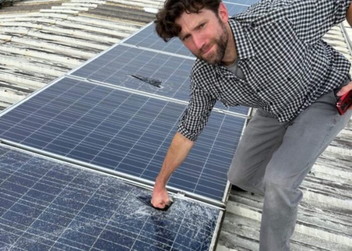 Person throwing a punch at a PV module that has been damaged by extreme weather